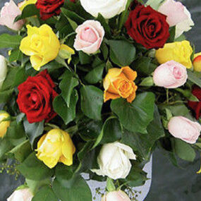 Bunter Blumenstrauß aus Rosen auf einem Boot vor Wasser, Trauerfloristik und Gedenken.